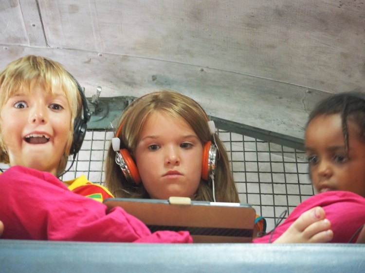 The children watch a film on the top bunk