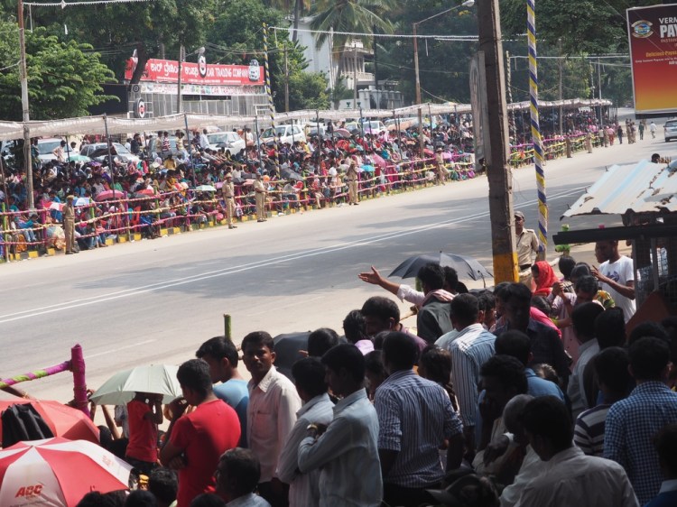 Throgs of people line &nbsp;the &nbsp; roads - &nbsp;even the barriers are wrapped in colourful cloths of silk and cotton