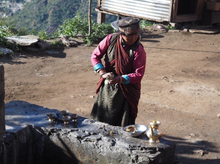 A local woman doing her daily washing of brass jug and cups, before filling with water and leaving in her home to appease the household god.&nbsp;