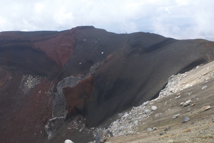 Notice the tiny little figure walking on the ridge of this rusty volcano