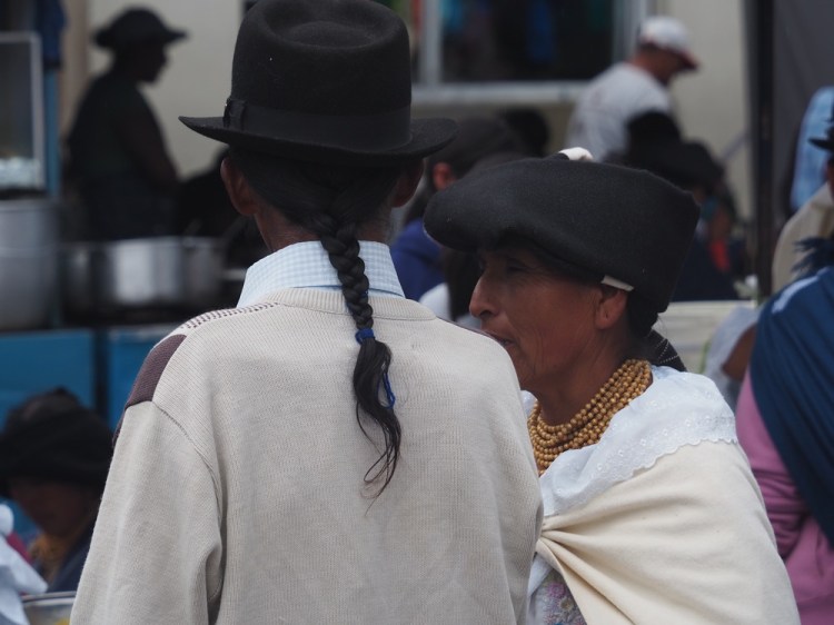 The men wear ponchos and have a long plait
