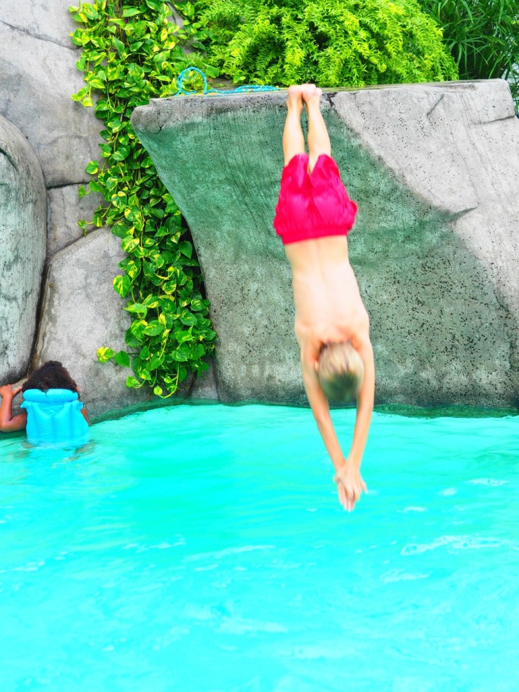 When we went to Guayaquil it was so fun. We had this amazing swimming pool with lots of rocks that you could dive off. In this picture it looks like I'm swinging from my toes and I'm going to hit my head against the rock - ouch! that would hurt - but I'm not, I'm doing a really cool dive